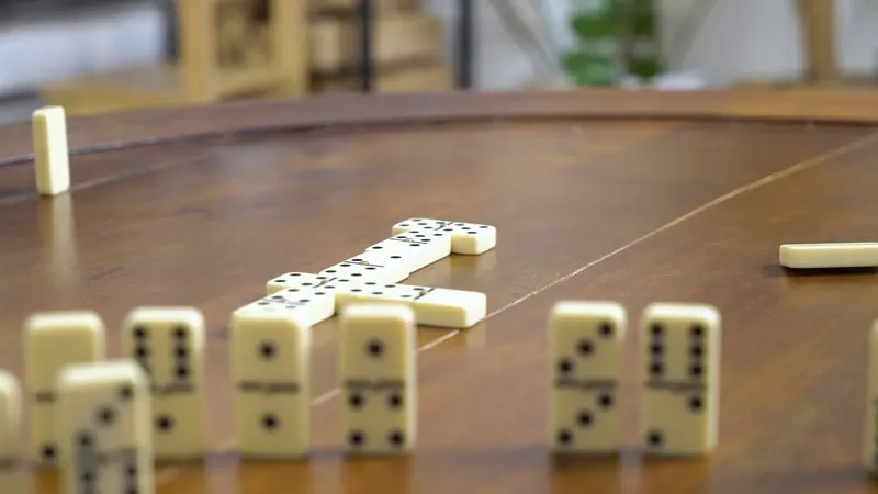 Dominoes mid-game on warm wood